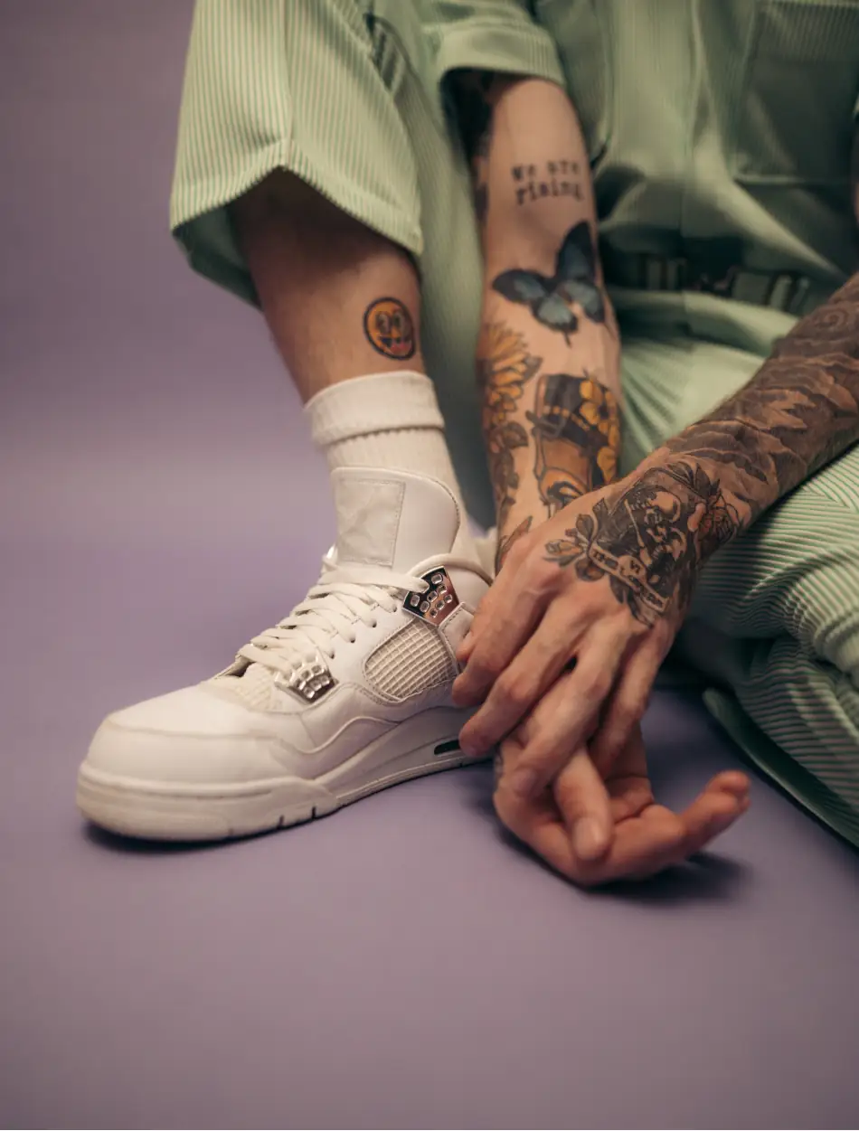Close up of a person with sport clothes and tattoos on a purple background